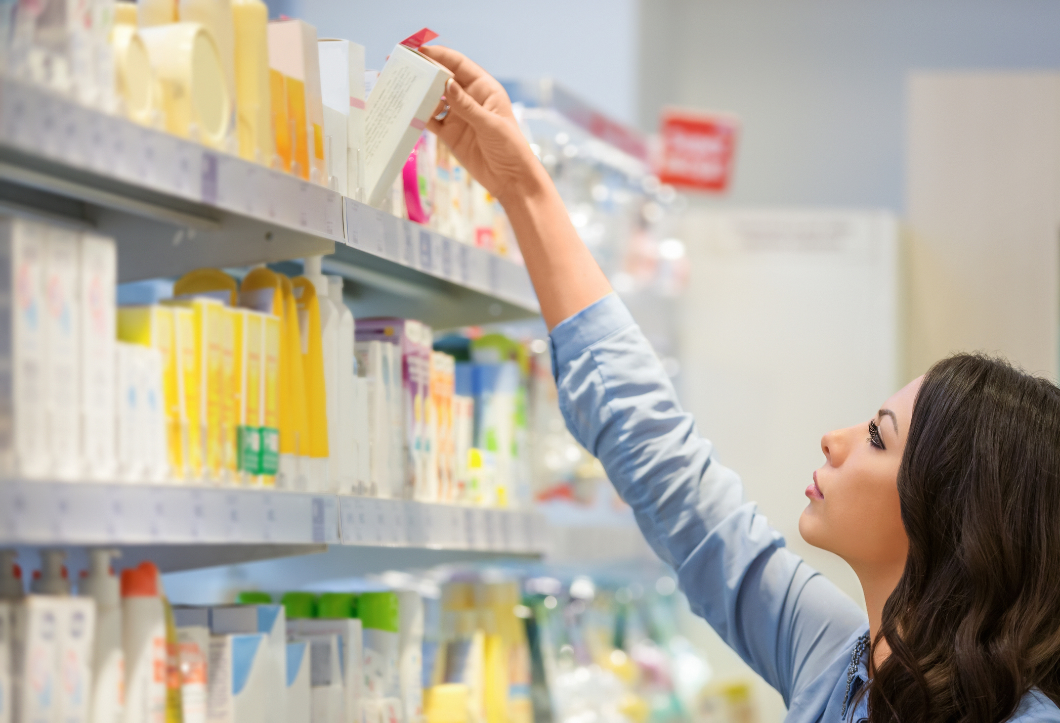 Woman reaching for body lotion in department store