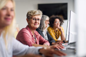 Image is of four women in front of screens smiling