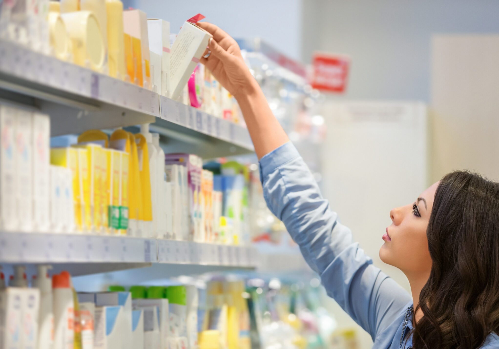 Woman reaching for body lotion in department store